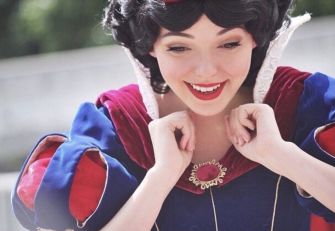 A performer in a Snow White costume smiling and expressing joy.