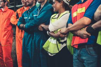 Group of workers wearing safety vests and uniforms standing together, possibly in a labor or union context.