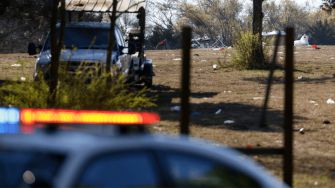 Scene of an outdoor concert venue in Dallas, showing debris and police vehicles after a shooting incident.