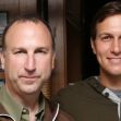 Two men standing close together, one wearing a jacket and the other dressed in a hoodie. Two men standing close together, one wearing a jacket and the other dressed in a hoodie.