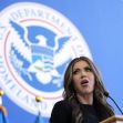 A woman speaking at a podium in front of the U.S. Department of Homeland Security seal. A woman speaking at a podium in front of the U.S. Department of Homeland Security seal.