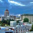 A view of downtown Fresno, California, featuring notable buildings against a cloudy sky. A view of downtown Fresno, California, featuring notable buildings against a cloudy sky.