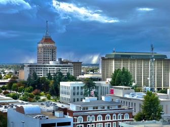 A view of downtown Fresno, California, featuring notable buildings against a cloudy sky.