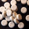Prescription opioid pills scattered on a surface. Prescription opioid pills scattered on a surface.