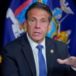 New York Governor Andrew Cuomo speaking at a press conference with state flags in the background. New York Governor Andrew Cuomo speaking at a press conference with state flags in the background.
