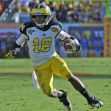 Denard Robinson running with the football during a game as a University of Michigan player. Denard Robinson running with the football during a game as a University of Michigan player.