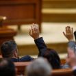 Members of Congress raising their hands to vote during a legislative session. Members of Congress raising their hands to vote during a legislative session.