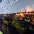 A child looking out from a bus window, with reflections of people and a queue visible outside, amidst the ongoing Ukrainian refugee crisis. A child looking out from a bus window, with reflections of people and a queue visible outside, amidst the ongoing Ukrainian refugee crisis.