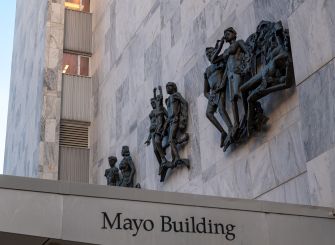 Facade of the Mayo Building with sculptures depicting various figures.