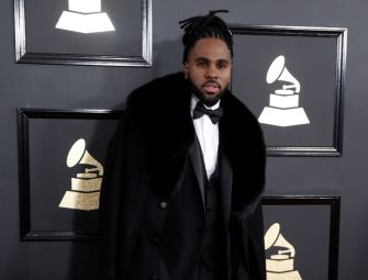 Pop singer Jason Derulo at a formal event, wearing a tuxedo with a fur-lined cape.
