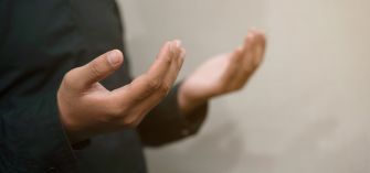A pair of hands in a prayer posture, reflecting a moment of devotion and spirituality.