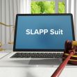 A gavel and laptop featuring the text "SLAPP Suit" on the screen, symbolizing legal discussions on anti-SLAPP laws. A gavel and laptop featuring the text "SLAPP Suit" on the screen, symbolizing legal discussions on anti-SLAPP laws.