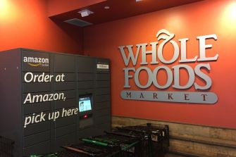 Amazon locker station at a Whole Foods Market, with signage indicating ordering and pickup options.