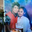 A framed photo of a man and woman together, with candles placed in front of it. A framed photo of a man and woman together, with candles placed in front of it.