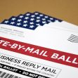 A stack of vote-by-mail ballots featuring a U.S. flag design. A stack of vote-by-mail ballots featuring a U.S. flag design.