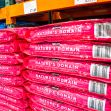 Stacks of Kirkland Nature's Domain dog food bags displayed in a Costco store. Stacks of Kirkland Nature's Domain dog food bags displayed in a Costco store.