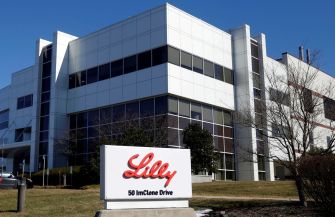 Exterior of the Eli Lilly corporate building with a sign displaying the company name and address.