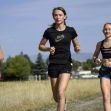 Three young female athletes running on a grassy path. Three young female athletes running on a grassy path.