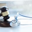 A gavel resting on a stack of law books beside a stethoscope, symbolizing the intersection of law and medicine in a medical malpractice case. A gavel resting on a stack of law books beside a stethoscope, symbolizing the intersection of law and medicine in a medical malpractice case.