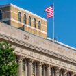 The facade of the United States Department of Agriculture building with an American flag waving above. The facade of the United States Department of Agriculture building with an American flag waving above.