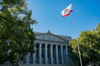 California courthouse with the state flag flying in front.