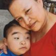 A woman embraces a young boy, both displaying affection, with the boy appearing to have special needs. A woman embraces a young boy, both displaying affection, with the boy appearing to have special needs.
