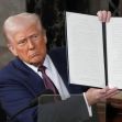 Former President Trump holding up an executive order during a press event. Former President Trump holding up an executive order during a press event.