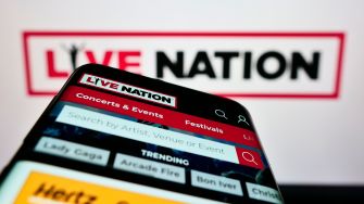 A smartphone displaying the Live Nation app with a logo in the background.