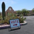 A sign instructing voters to the polling place amidst desert vegetation in Arizona. A sign instructing voters to the polling place amidst desert vegetation in Arizona.