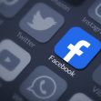 An image of a smartphone screen displaying various app icons, with the Facebook app prominently featured in blue. An image of a smartphone screen displaying various app icons, with the Facebook app prominently featured in blue.