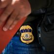 Close-up of an ICE officer's badge attached to their uniform during immigration enforcement operations. Close-up of an ICE officer's badge attached to their uniform during immigration enforcement operations.