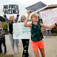 A group of protesters holding signs advocating for freedom of choice regarding vaccinations during a demonstration. A group of protesters holding signs advocating for freedom of choice regarding vaccinations during a demonstration.