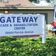 Signage for Gateway Care & Rehabilitation Center, with a staff member attending to a patient nearby. Signage for Gateway Care & Rehabilitation Center, with a staff member attending to a patient nearby.