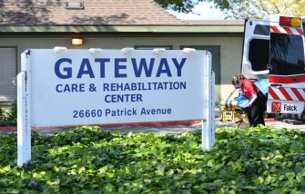 Signage for Gateway Care & Rehabilitation Center, with a staff member attending to a patient nearby.