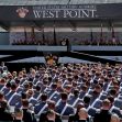 A large gathering of West Point cadets listening to a speaker at a ceremony, with the West Point banner displayed prominently in the background. A large gathering of West Point cadets listening to a speaker at a ceremony, with the West Point banner displayed prominently in the background.