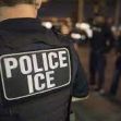 A law enforcement officer in a tactical vest with "POLICE ICE" visible on the back, standing with other officers in a nighttime setting. A law enforcement officer in a tactical vest with "POLICE ICE" visible on the back, standing with other officers in a nighttime setting.