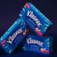 Stacked boxes of Kleenex tissues in bright blue packaging against a dark background. Stacked boxes of Kleenex tissues in bright blue packaging against a dark background.