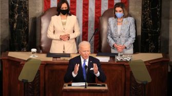 President Biden speaks at a congressional event, flanked by Vice President Kamala Harris and House Speaker Nancy Pelosi.