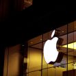 Apple logo illuminated at night on a store facade. Apple logo illuminated at night on a store facade.