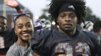 A photo of Ronnie Caldwell, Jr. in football practice, standing with a female teammate who is smiling.