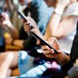 Group of students sitting together, each using their smartphones. Group of students sitting together, each using their smartphones.