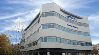 Exterior view of a Compass Medical facility with a clear sky in the background.