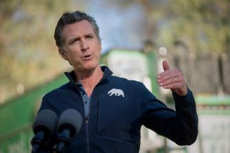 California Governor Gavin Newsom speaking during a press event, with a focus on public policy.