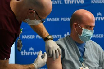A healthcare worker administering a COVID-19 vaccine to a patient at a vaccination site.