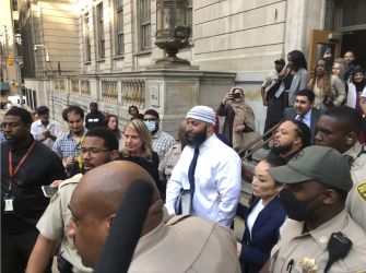 Adnan Syed surrounded by a crowd outside a courthouse after his conviction was vacated, marking the end of 23 years behind bars.