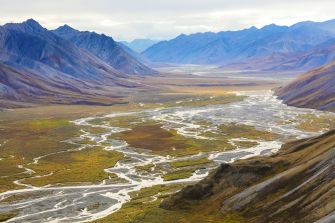 A scenic view of the Arctic National Wildlife Refuge, showcasing its diverse landscapes of mountains, rivers, and valleys.