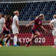 A scene from a women's soccer match, showing players from both teams near the goal area. A scene from a women's soccer match, showing players from both teams near the goal area.