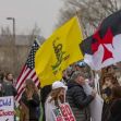 A group of protesters holding signs and flags during a demonstration related to school policies in Iowa. A group of protesters holding signs and flags during a demonstration related to school policies in Iowa.