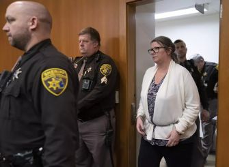 Jennifer Crumbley, mother of school shooter Ethan Crumbley, entering a courtroom surrounded by law enforcement after being found guilty of involuntary manslaughter.
