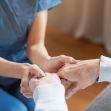 A caregiver holding hands with an elderly person, symbolizing support and care. A caregiver holding hands with an elderly person, symbolizing support and care.